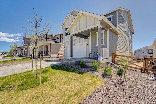 view of front of house with board and batten siding, a porch, a garage, a residential view, and a front lawn