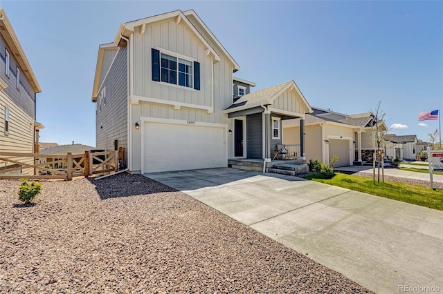 view of front of property featuring board and batten siding, concrete driveway, an attached garage, and a gate