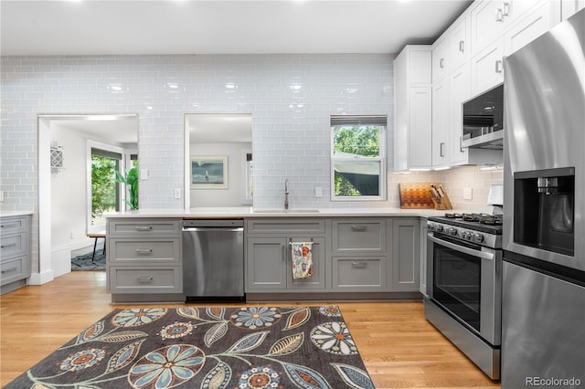 4501 Zenobia St, Denver, CO 80212 - kitchen with stainless steel appliances, gray cabinets, light wood-style flooring, and light countertops
