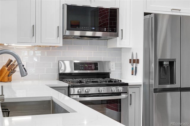 4501 Zenobia St, Denver, CO 80212 - kitchen with appliances with stainless steel finishes, tasteful backsplash, and white cabinets