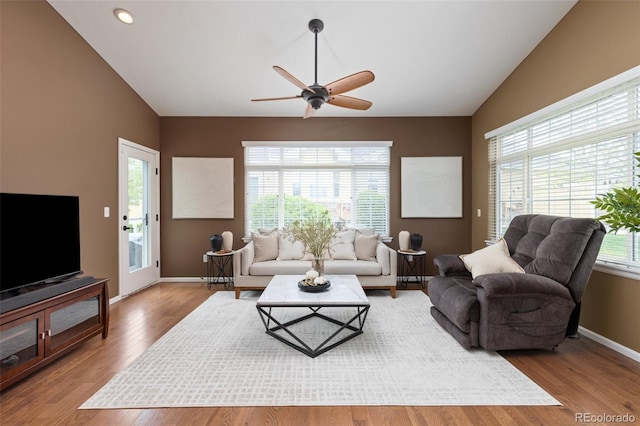 living room featuring lofted ceiling, ceiling fan, wood finished floors, baseboards, and recessed lighting
