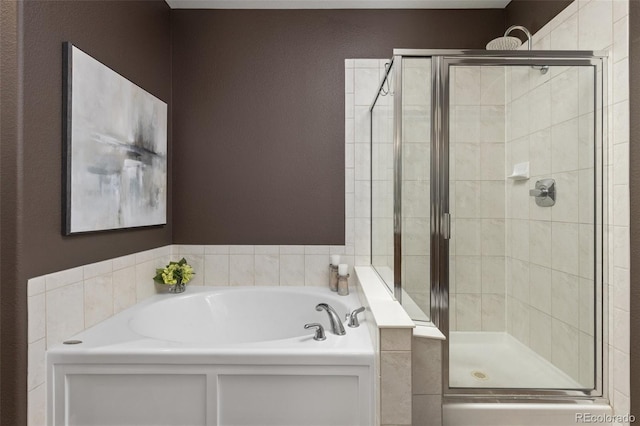 bathroom featuring a bath and a shower stall