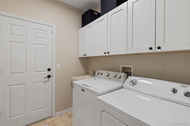 laundry room with washing machine and clothes dryer, cabinet space, baseboards, and light stone finish flooring