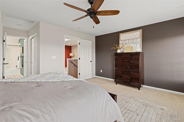 carpeted bedroom featuring baseboards, ensuite bathroom, and ceiling fan