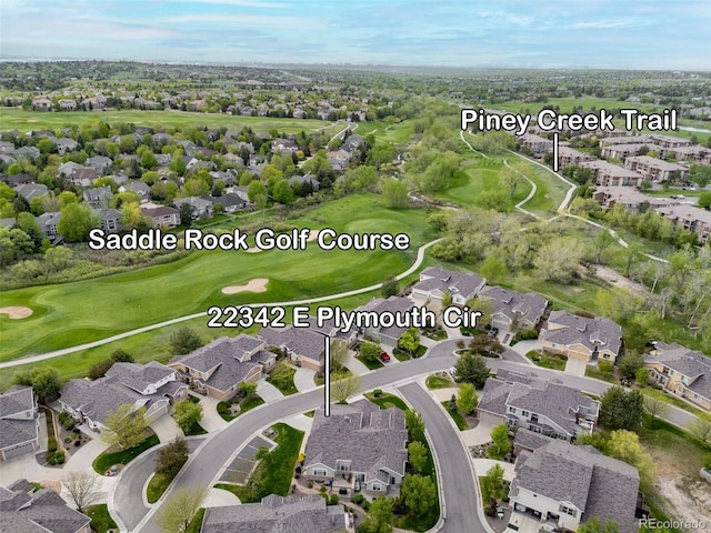 aerial view of property and surrounding area featuring nearby suburban area and a golf club
