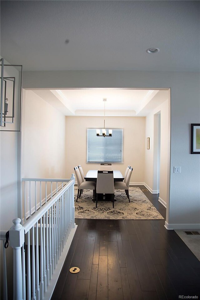 3910 Mighty Oaks St, Castle Rock, CO 80104 - dining space with a chandelier, dark wood finished floors, baseboards, and a raised ceiling