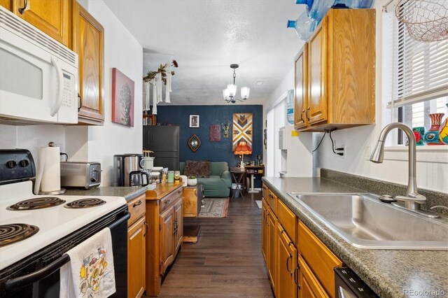 2277 S Buckley Rd Unit 102, Aurora, CO 80013 - kitchen with white microwave, range with electric stovetop, a sink, freestanding refrigerator, and a chandelier
