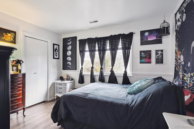 2277 S Buckley Rd Unit 102, Aurora, CO 80013 - bedroom featuring wood finished floors, a wainscoted wall, and a closet