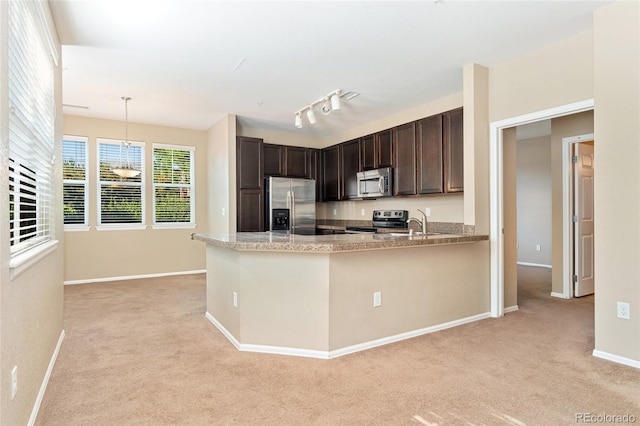 9637 E 5th Ave Unit 101, Denver, CO 80230 - kitchen featuring appliances with stainless steel finishes, light colored carpet, dark brown cabinetry, and a peninsula