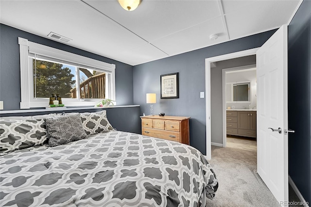 carpeted bedroom featuring baseboards, visible vents, and a sink