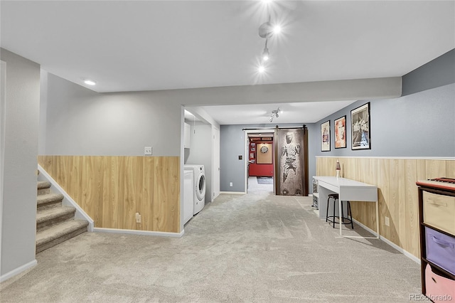 interior space with wooden walls, washer and dryer, carpet, and a wainscoted wall