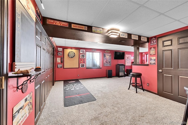 recreation room featuring baseboards, a paneled ceiling, and carpet