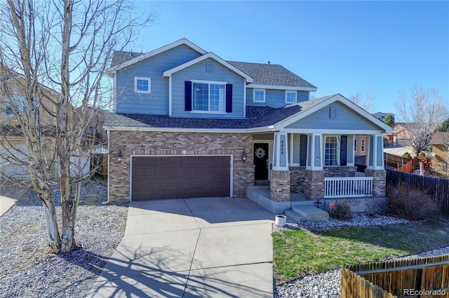 craftsman-style home with a porch, roof with shingles, fence, an attached garage, and driveway
