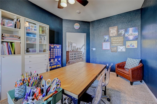 home office with carpet flooring, ceiling fan, a textured wall, and baseboards