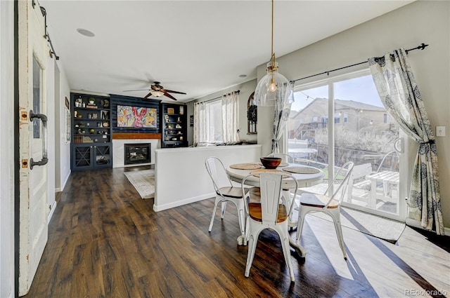 dining room with ceiling fan, wood finished floors, and baseboards