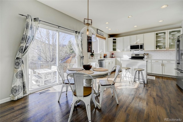 dining room with dark wood-style flooring, baseboards, visible vents, and recessed lighting