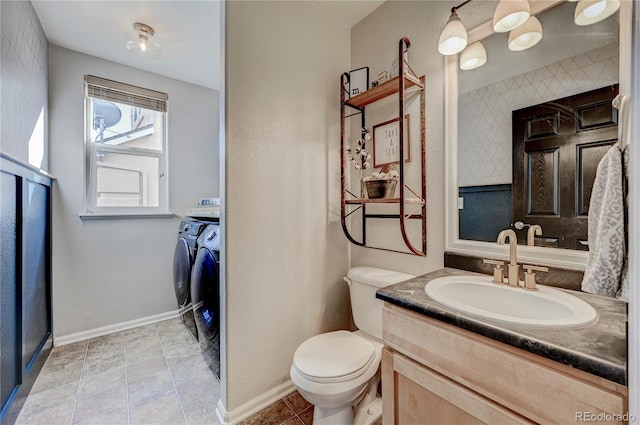 bathroom featuring washer and dryer, vanity, baseboards, and toilet