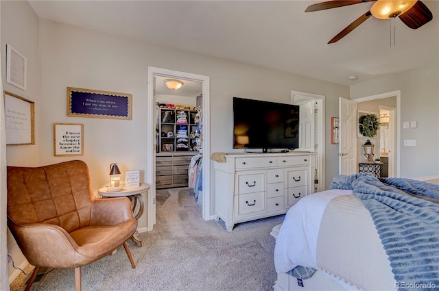 bedroom featuring a closet, a spacious closet, ceiling fan, and light colored carpet