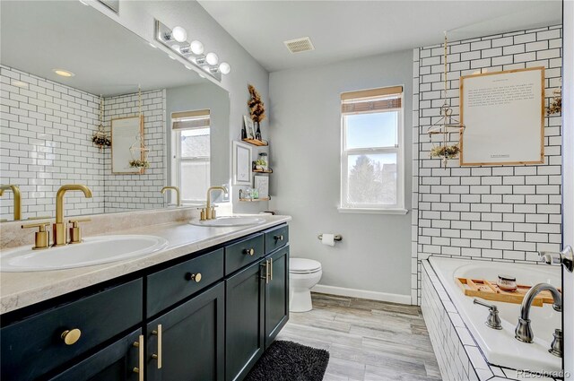 bathroom with a sink, visible vents, and plenty of natural light