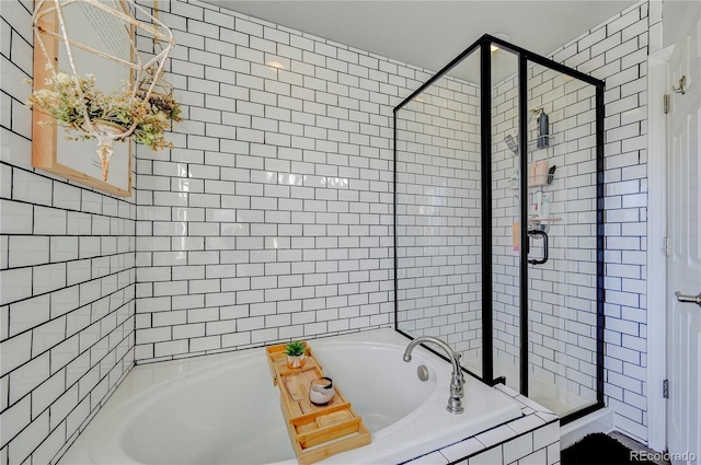 bathroom featuring a shower stall and a bath