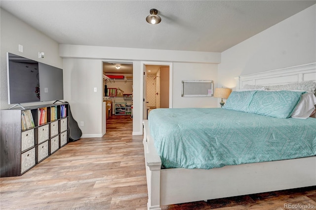 bedroom featuring a closet, a walk in closet, and wood finished floors