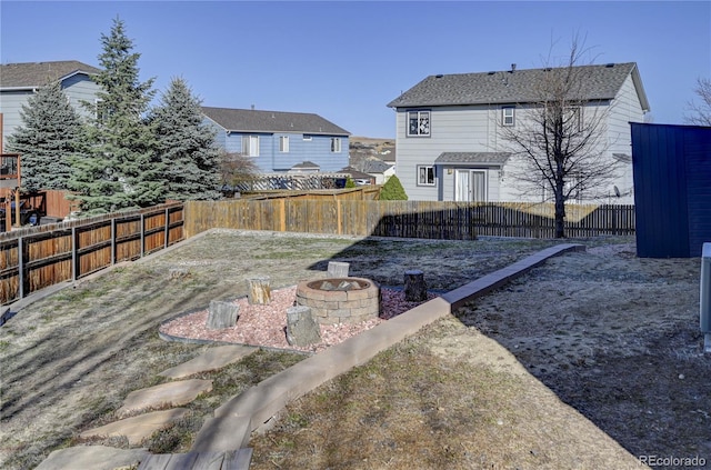view of yard with a fenced backyard and a fire pit