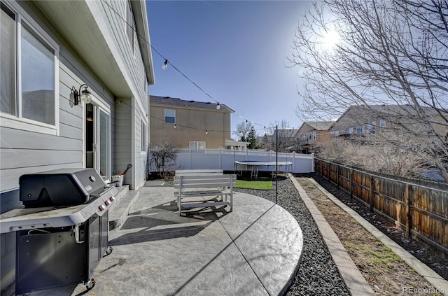 view of patio / terrace with a fenced backyard, a trampoline, and area for grilling