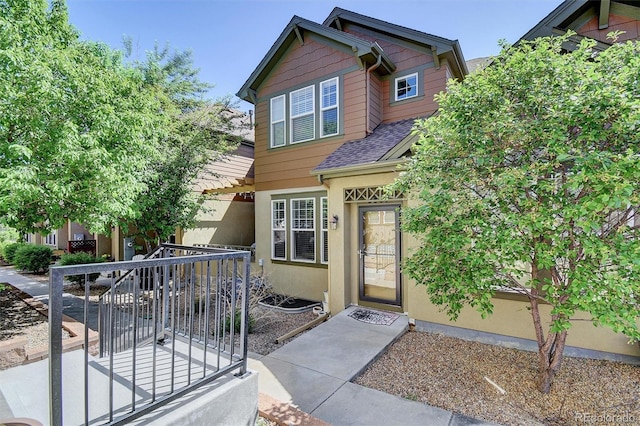 craftsman house with stucco siding and a shingled roof