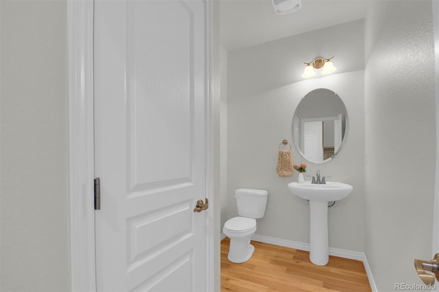 bathroom featuring wood finished floors, toilet, and baseboards