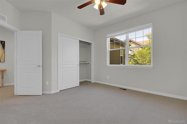unfurnished bedroom with light carpet, a closet, baseboards, and a ceiling fan