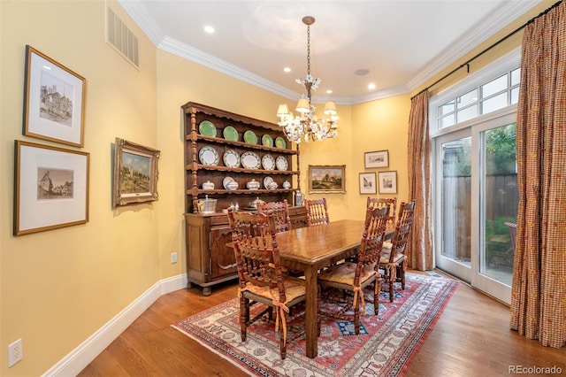 dining room with a notable chandelier, ornamental molding, visible vents, and baseboards