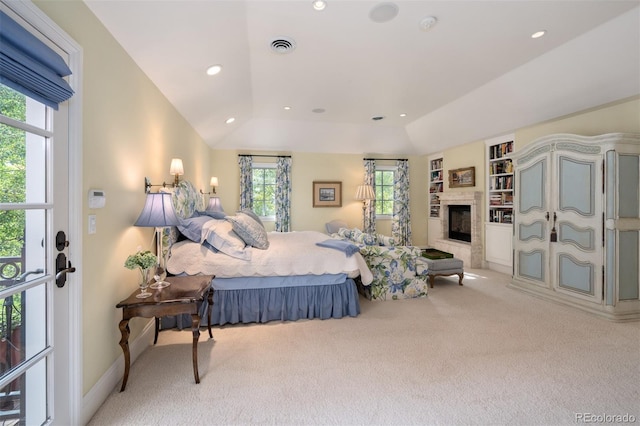 bedroom featuring light carpet, a glass covered fireplace, visible vents, and recessed lighting