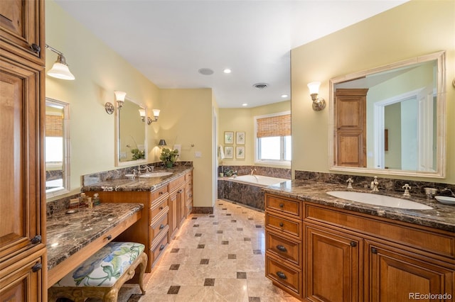 full bath with a garden tub, two vanities, a sink, and visible vents