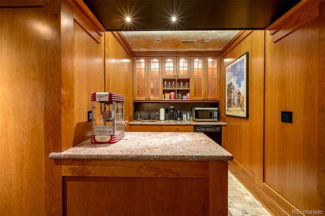 bar featuring indoor bar, wood walls, backsplash, dishwasher, and stainless steel microwave