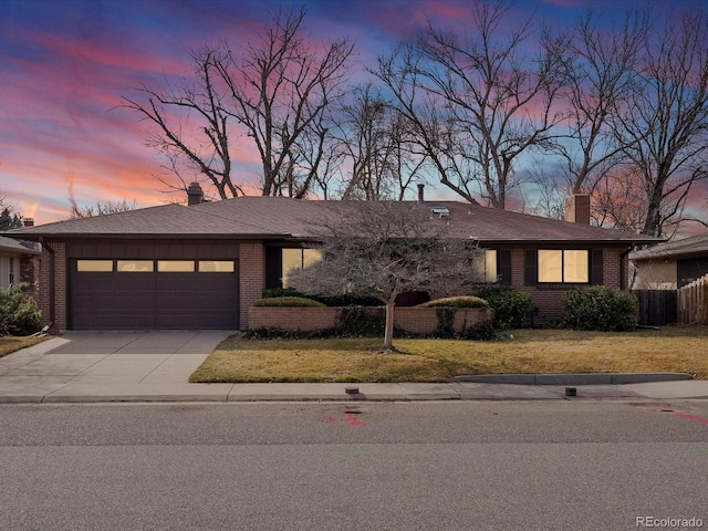 view of front facade with brick siding, driveway, a chimney, and an attached garage