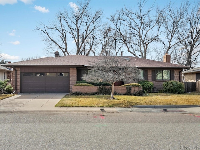 ranch-style home featuring a garage, brick siding, a chimney, and a front yard