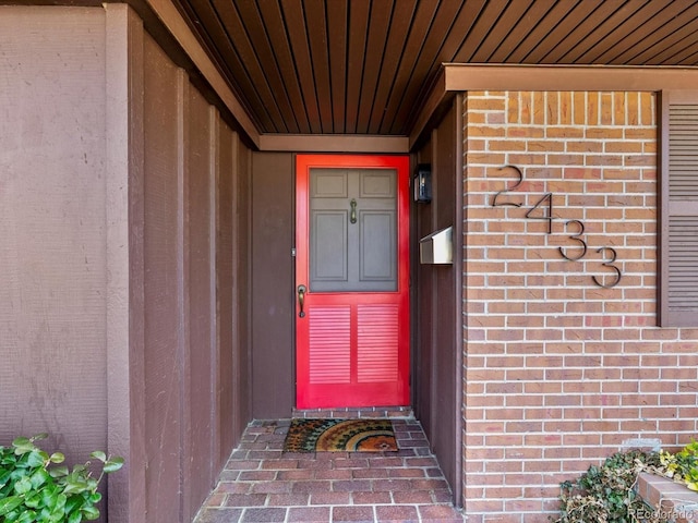 doorway to property with brick siding