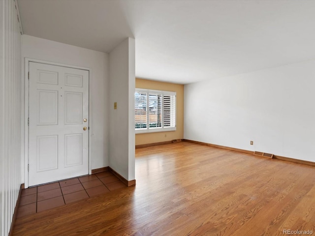 interior space with visible vents, baseboards, and wood finished floors