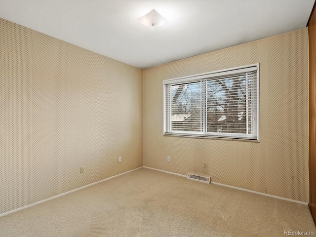 unfurnished room with light carpet, baseboards, and visible vents