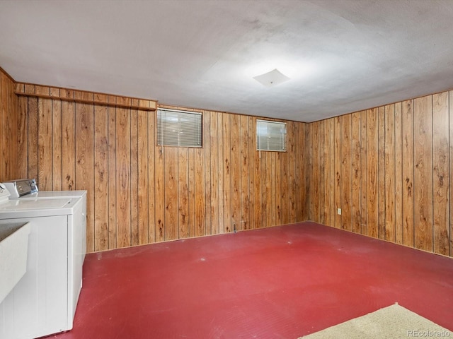 finished basement featuring wood walls and independent washer and dryer