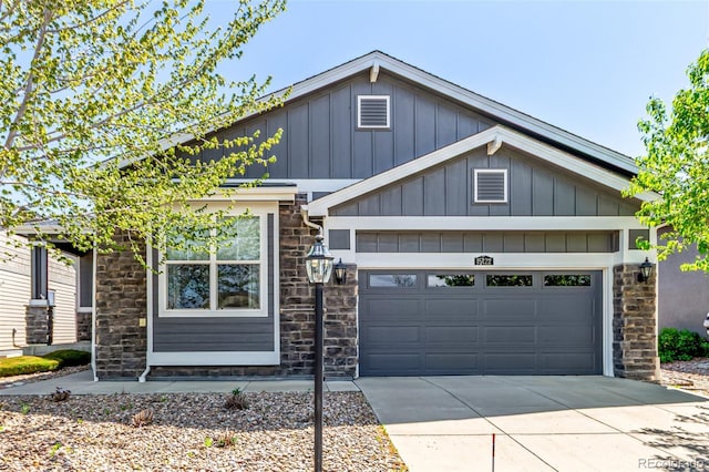 craftsman house with board and batten siding, an attached garage, driveway, and stone siding