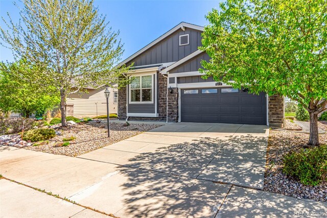 craftsman house with an attached garage, board and batten siding, driveway, and stone siding