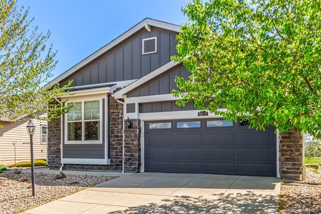 view of front of house featuring an attached garage, board and batten siding, stone siding, and concrete driveway