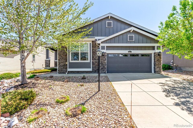 craftsman-style home with a garage, board and batten siding, stone siding, and concrete driveway