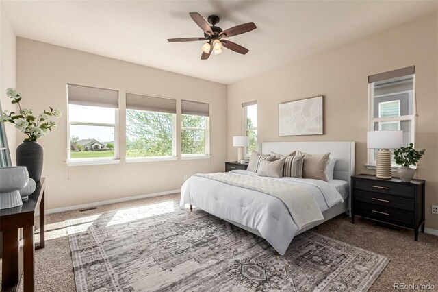carpeted bedroom with baseboards, ceiling fan, and visible vents