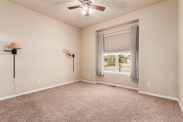 carpeted empty room featuring visible vents, baseboards, and ceiling fan