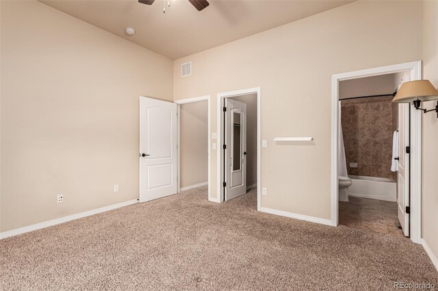 unfurnished bedroom featuring ceiling fan, visible vents, baseboards, connected bathroom, and carpet