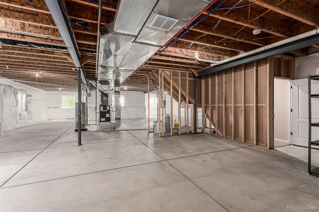 basement featuring heating unit, gas water heater, and visible vents