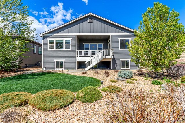 back of property featuring a yard and stairs