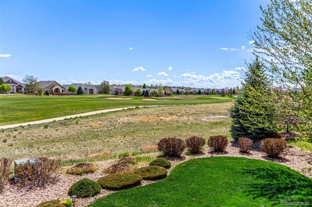 view of home's community featuring a lawn, golf course view, and a residential view